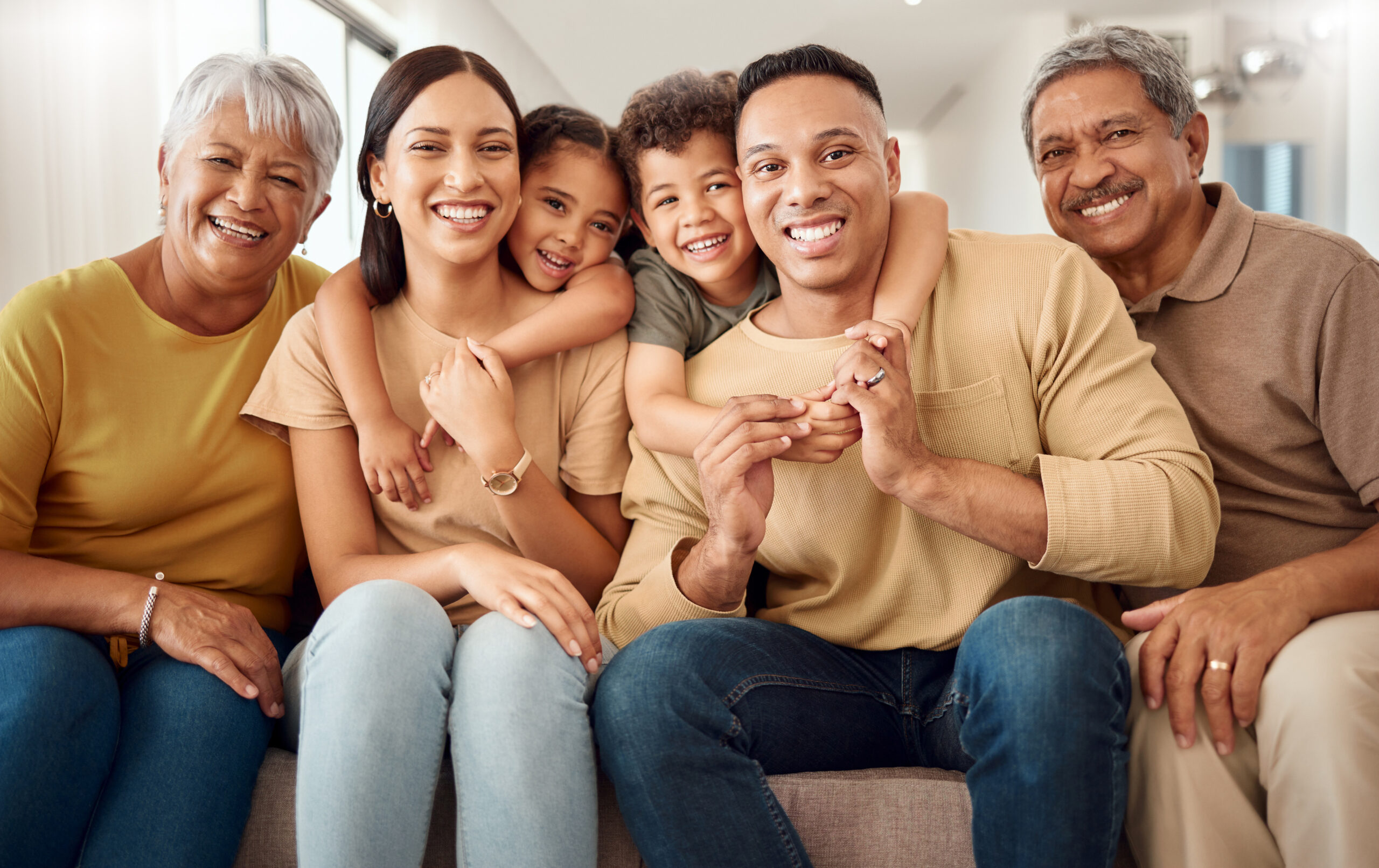 House, portrait and happy big family love enjoying quality time, gathering and having fun bonding in Colombia. Mother, father and elderly grandparents relaxing on a sofa with young children siblings.